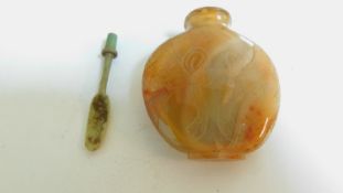 An antique Chinese carved agate snuff bottle with engraved bow and fabric design and original bone