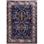 A fine Kazak style rug with double central medallions on indigo field with stylised animal and