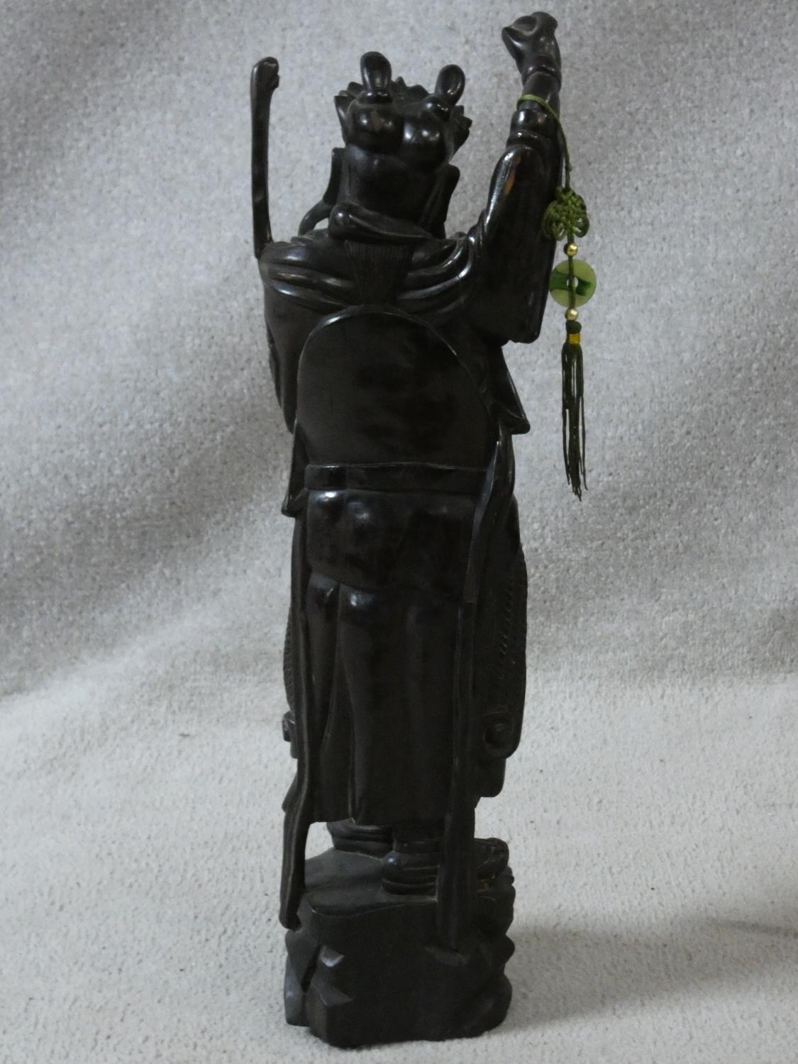 A Chinese carved hardwood figure of an immortal with jade bi disc on silk cord hanging from his - Image 5 of 5