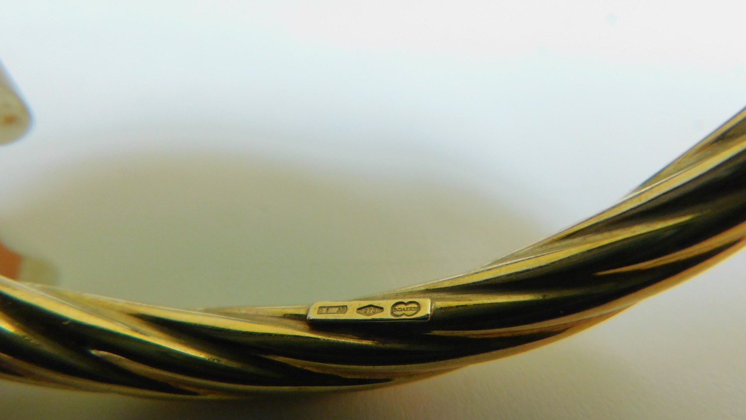 A vintage 9 ct yellow gold hollow twist bangle with secure loop clasp. Italian hallmarks, stamped - Image 3 of 4
