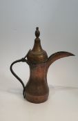 A large Islamic Arabic Dallah copper coffee pot with hammered design. H.43x38cm