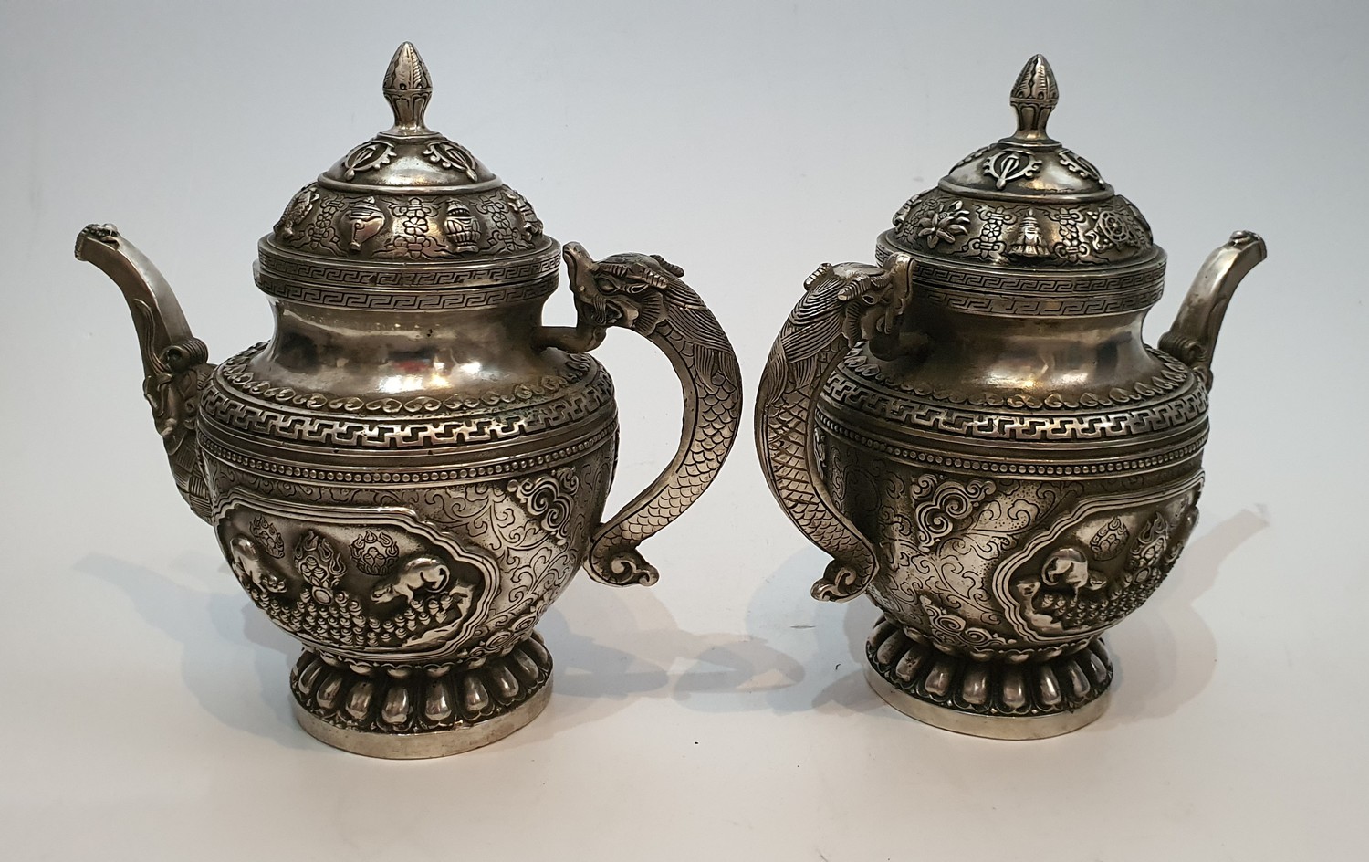 A pair of Chinese Tibetan white metal repousse design wine jugs. Decorated with animals, symbols and - Image 4 of 5