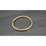 A vintage 9 ct yellow gold hollow twist bangle with secure loop clasp. Italian hallmarks, stamped