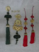 A collection of Chinese carved jade and silk cord talismans. W.57cm