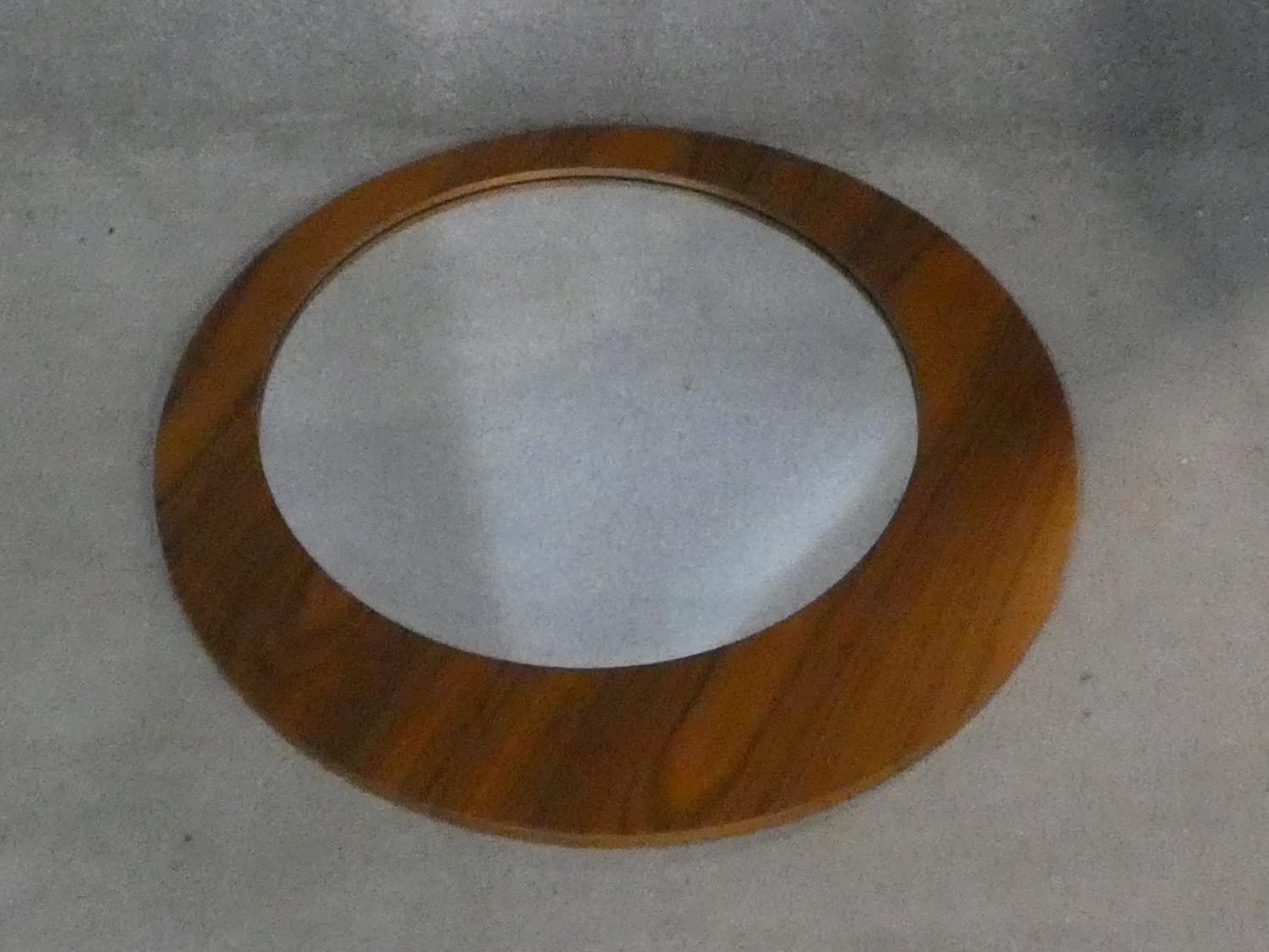A contemporary wall mirror with off set circular plate. D.75cm