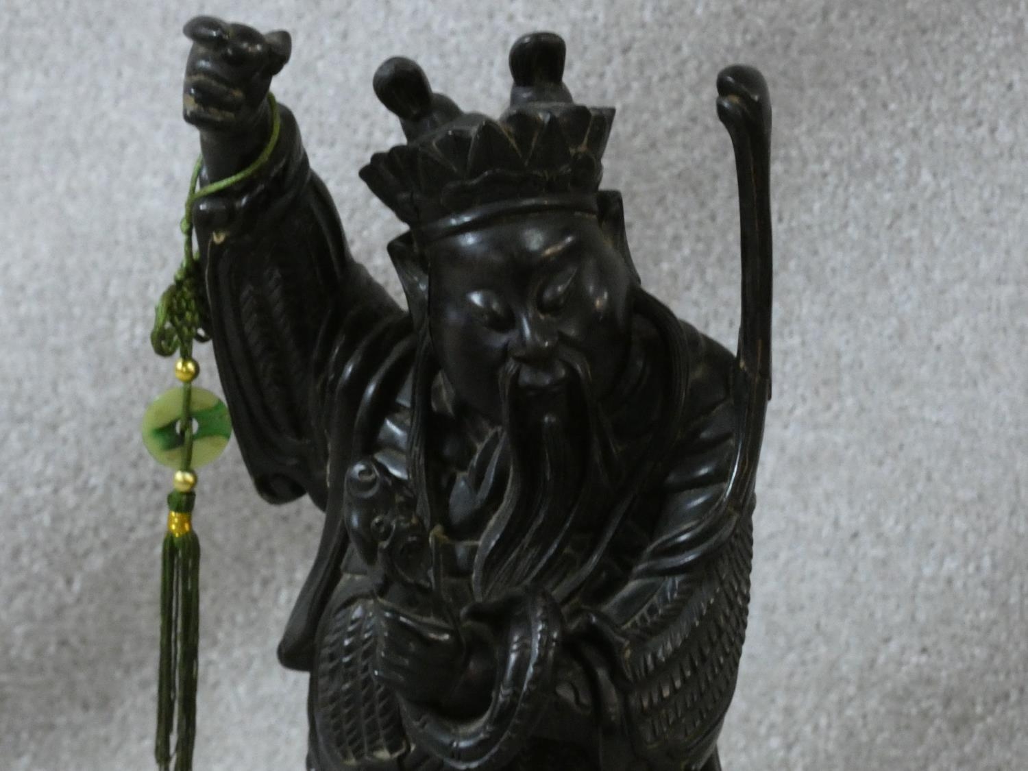 A Chinese carved hardwood figure of an immortal with jade bi disc on silk cord hanging from his - Image 2 of 5