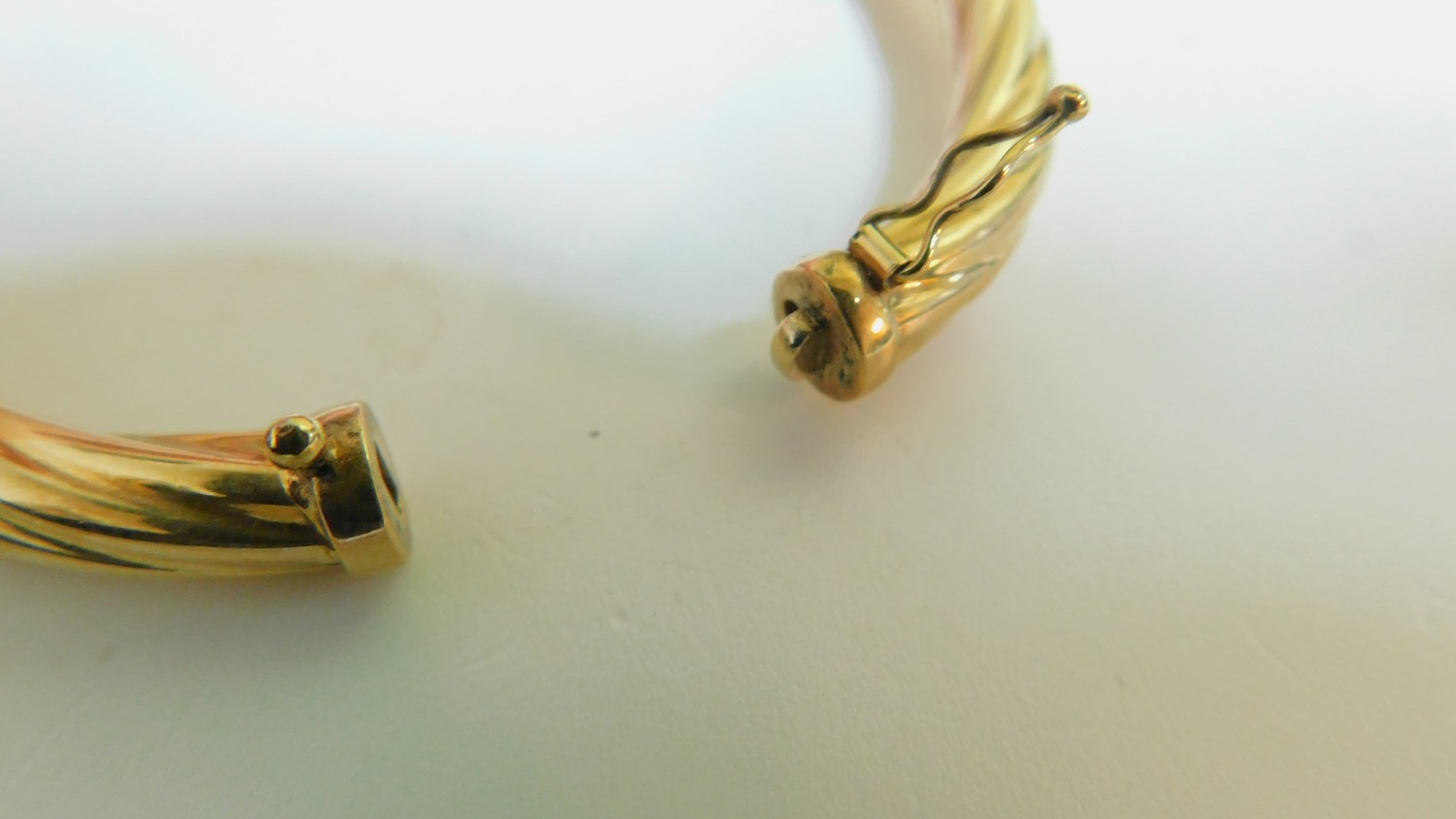 A vintage 9 ct yellow gold hollow twist bangle with secure loop clasp. Italian hallmarks, stamped - Image 4 of 4
