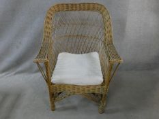 A wicker conservatory armchair with fitted cushion. H.96cm