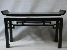 A contemporary Chinese style console table with tray top above pierced frieze on square supports.