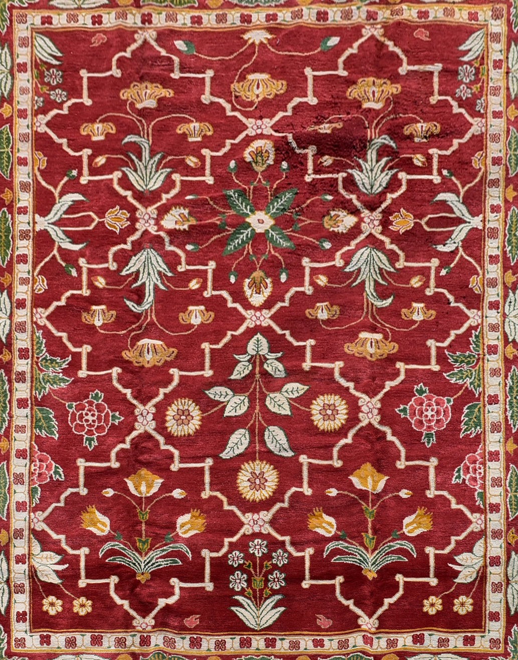 A Moughal design carpet with repeating stylised floral pattern across a madder ground within foliate - Image 2 of 4