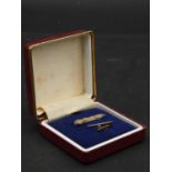 A white engraved metal signed boxed tie pin of the classic American Auburn sports car with push