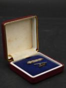 A white engraved metal signed boxed tie pin of the classic American Auburn sports car with push