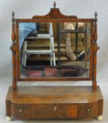 An early 19th century mahogany and satinwood strung toilet mirror with triple bronze acorn finials