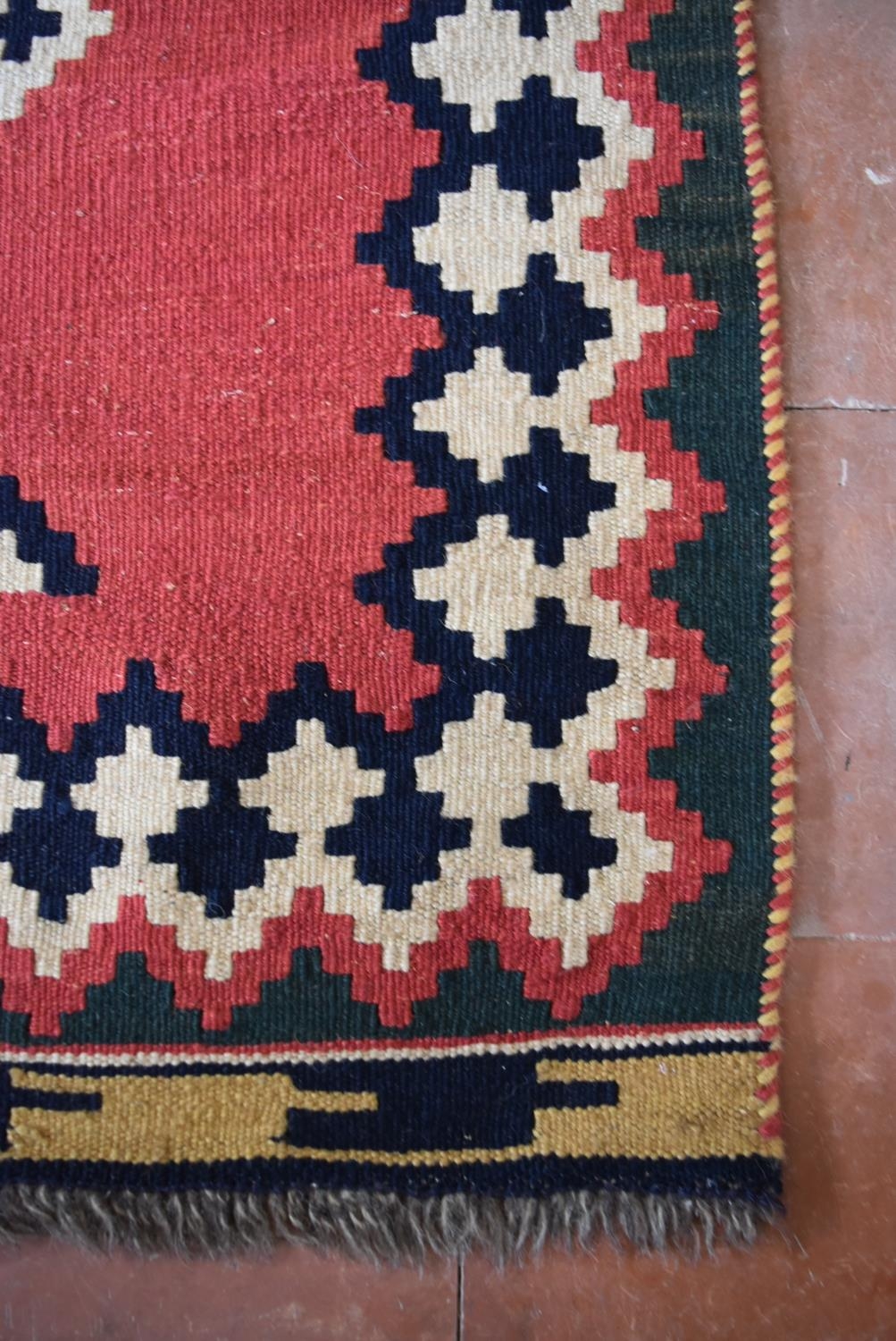 A Persian Kashkai Kilim with repeating diamond pattern on a blush field within geometric borders. - Image 3 of 4