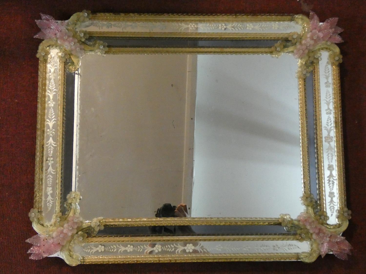 A Murano glass wall mirror with polychrome floral decoration and etched panels. H.70 W.87cm