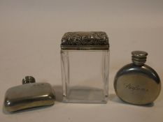 Two pewter perfume bottles with A quality mark along with a silver repousse floral design topped