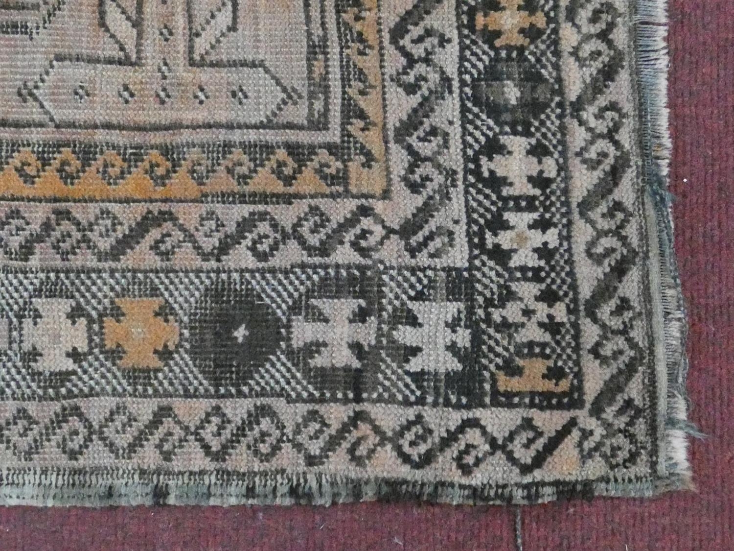 An Eastern rug with repeating gul motifs across the madder field within highly stylised foliate - Image 3 of 5