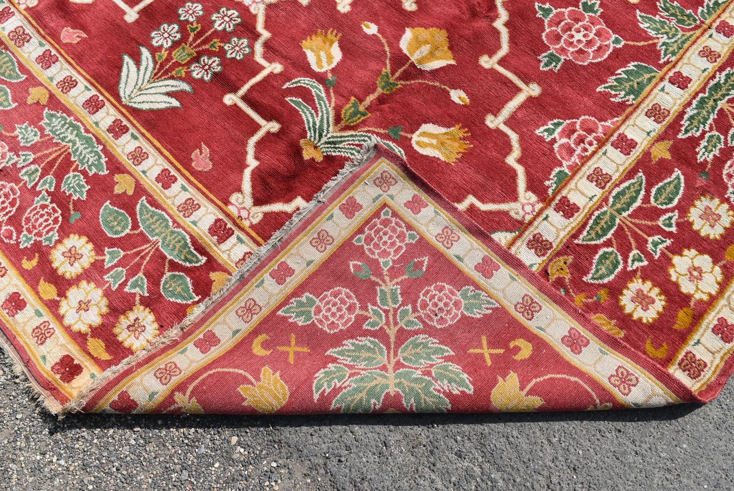 A Moughal design carpet with repeating stylised floral pattern across a madder ground within foliate - Image 4 of 4