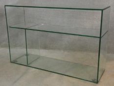 A modernist design plate glass open display side cabinet. H.77 W.118 D.35cm