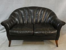 A vintage Tetrad scallop shaped two seater sofa in tobacco leather upholstery on swept supports. H.