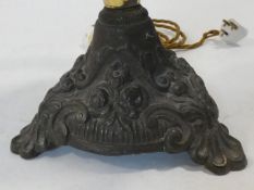 A 19th century oil lamp with clear glass reservoir on cast metal base converted to electricity. H.