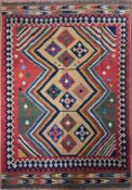 A Persian Kashkai Kilim with repeating diamond medallions on polychrome field contained by geometric