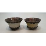 A pair of Chinese carved jade and white metal lined cups with white metal filigree wire work inset