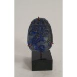 A Chinese carved lapis lazuli pendant with a lucky bat, coins and fungi. Mounted on a metal