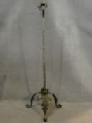 A vintage wrought iron standard lamp stand with spiral twist central column on tripod scrolling