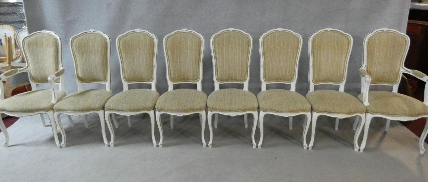 A set of eight Louis XV style distressed painted and gilt dining chairs in fawn upholstery on