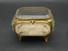 A French antique bevelled glass gilt metal jewellery box with silk button cushion to base. H.8 L.