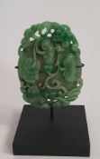 A Chinese pierced jade carving, decorated with pea pods on a bi disc for immortality, lucky bats and