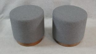 A pair of cylindrical stools upholstered in grey calico on cherrywood plinth bases. H.39cm