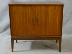 A mid century teak side cabinet with a pair of bi-fold panel doors. H.82 W.84 D.41cm