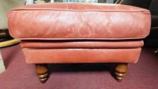 A leather upholstered footstool on turned tapering supports. H.37 W.58 D.58