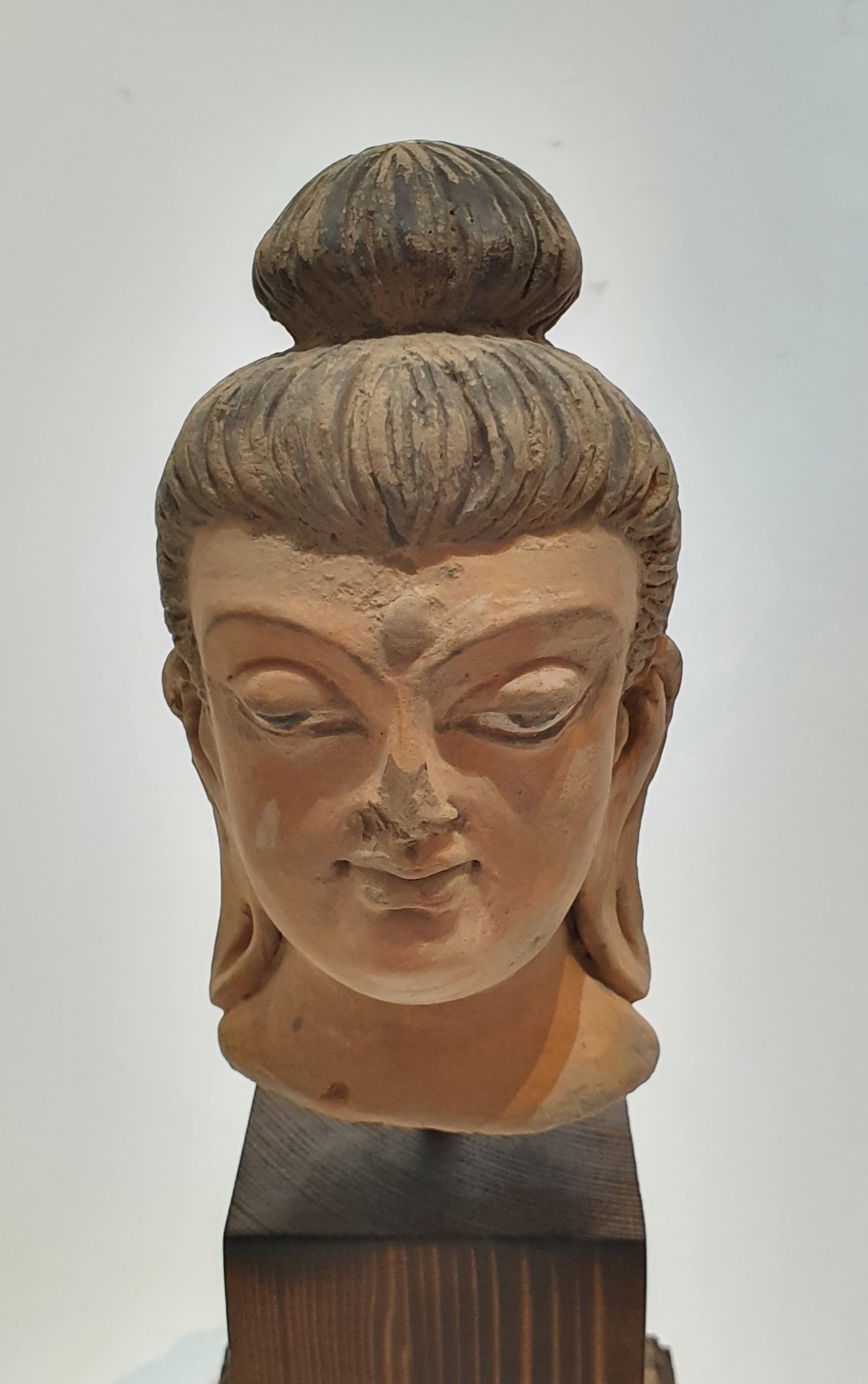 A Chinese terracotta head of buddha with painted details, mounted on a wooden stand. H27cm. - Image 2 of 4