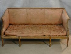 A 19th century carved giltwood canape upholstered in blush damask and fitted with long squab cushion