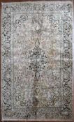A silk Kashmir rug with central pendant medallion and scrolling floral design on a pale pink
