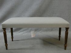 A Regency style window seat in calico upholstery on reeded tapering supports. H.48 L.98 W.40cm