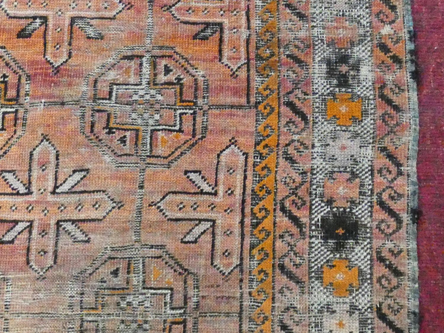 An Eastern rug with repeating gul motifs across the madder field within highly stylised foliate - Image 4 of 5