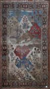 An antique Persian pictorial rug with animals and foliage in a mountain setting within stylised