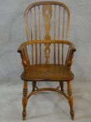 A 19th century elm Windsor armchair with pierced splat above moulded seat on turned supports