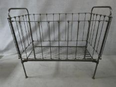A Victorian wrought iron child's cot with fall front panel. H.114 L.124 W.63cm