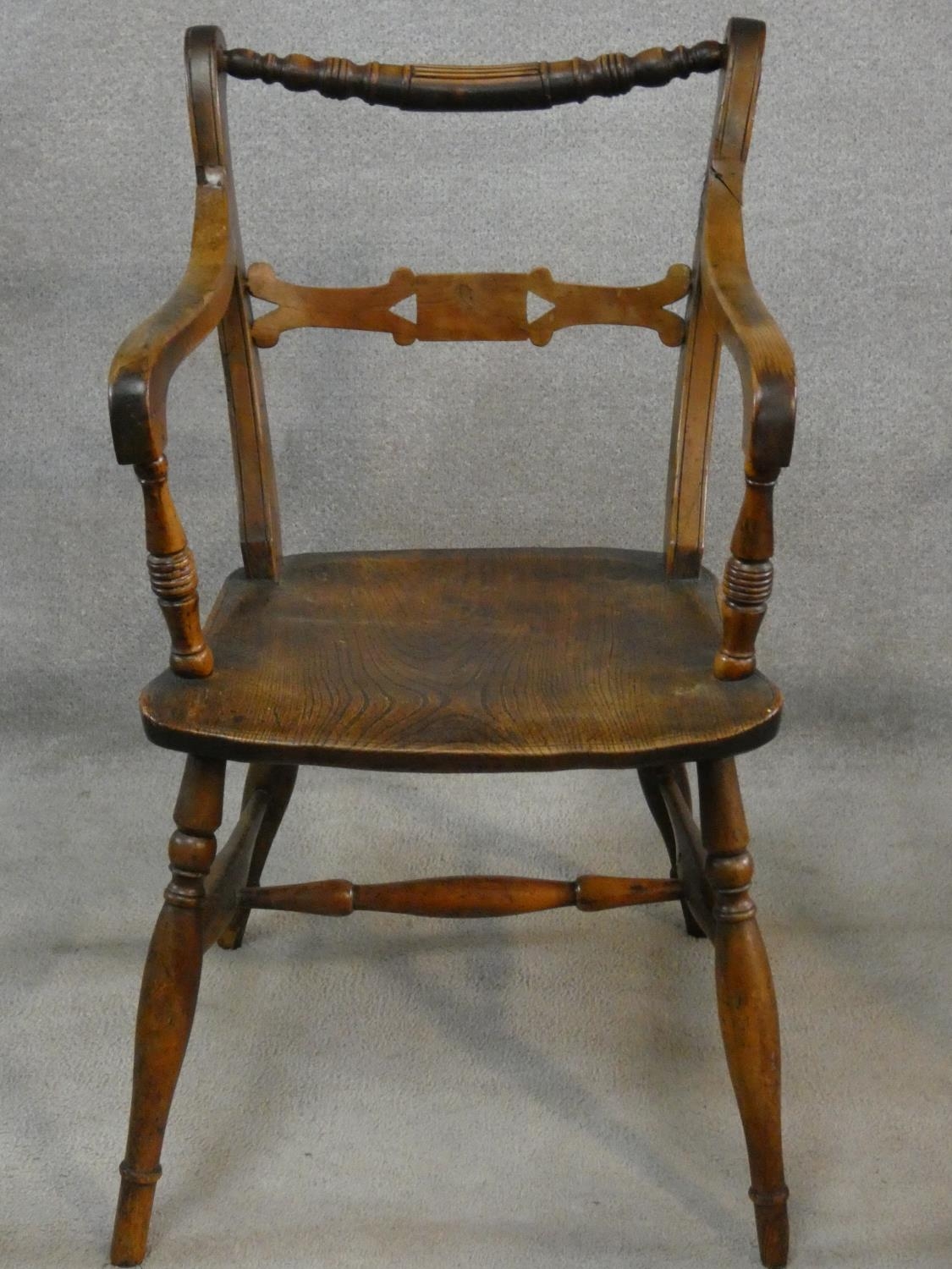 A 19th century beech framed armchair with moulded elm seat on turned stretchered supports. H.87cm