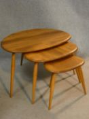 A vintage nest of three light elm and beech Ercol pebble tables. H.41 L.65 W.44cm