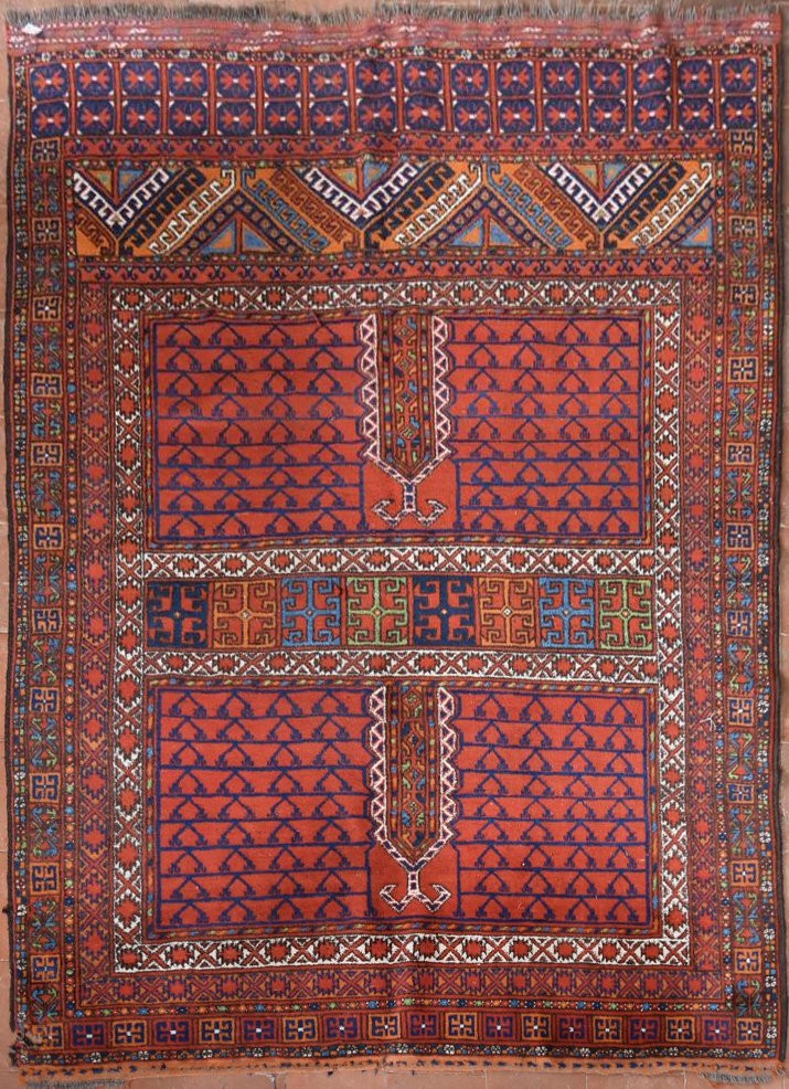 An Afghan rug with geometric design across the madder field within stylised floral borders. L.