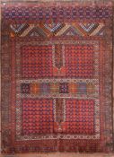 An Afghan rug with geometric design across the madder field within stylised floral borders. L.