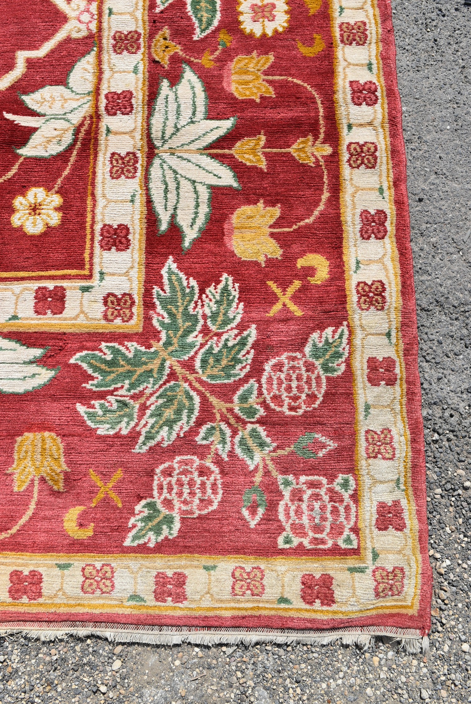 A Moughal design carpet with repeating stylised floral pattern across a madder ground within foliate - Image 3 of 4