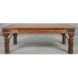 An Indian teak and metal bound coffee table on circular section supports. H.41 L.110 D.60cm