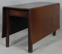 A Georgian mahogany drop flap dining table with gateleg action raised on square section supports.